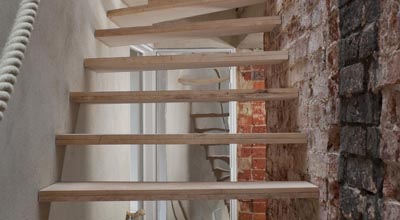 Wooden stairs with hemp handle and soot on wall at zero carbon house, Birmingham