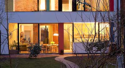 The lights on inside the zero carbon house, Birmingham, taken from the garden, showing what is happening in the living room