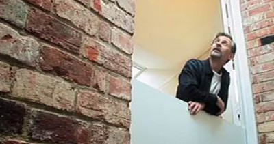 John Christophers, architect, looks through the internal shutters in zero carbon house. Birmingham