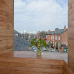 Tulips in a vase on the window sill of the alcove of the studio, zero carbon house, Birmingham with view of Tindal St