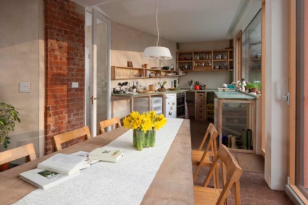 Dining table with daffodils in the open plan living area and kitchen in zero carbon house Birmingham