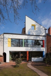 Back of the zero carbon house, Birmingham, as seen from the garden with red, yellow, blue and green splashes of colour on render