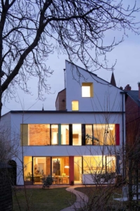 Back of zero carbon house, Birmingham at night with lights showing the inside of the house