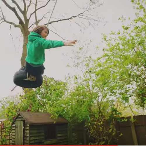 Theo swinging on a tyre at zero carbon house, Birmingham